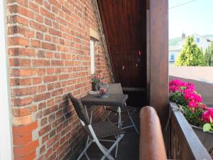 d'une terrasse avec 2 chaises et une table sur un mur en briques. dans l'établissement Fischhus Bormann, à Sassnitz