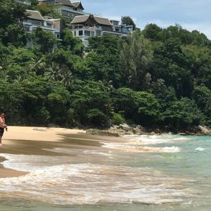 a person walking on the beach near the water at Nai Thon Condo Unit in Nai Thon Beach