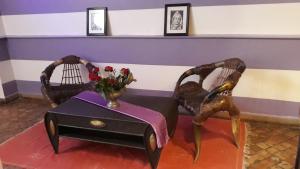 Zimmer mit 2 Stühlen und einem Tisch mit einer Blumenvase in der Unterkunft Casa Lila & Spa in Essaouira