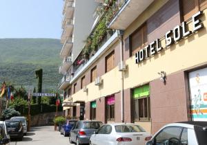 eine Straße mit Autos, die vor einem Gebäude geparkt sind in der Unterkunft Hotel Sole in Nocera Inferiore