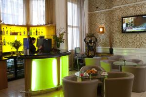 a restaurant with green lighting and tables and chairs at Park Grand Paddington Court in London