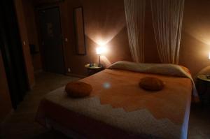 a bedroom with a bed with two pumpkins on it at Hotel Le Saint Jean in Ersa
