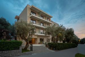 a building with trees in front of it at Hotel Eleven in Petrovac na Moru
