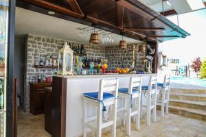 a kitchen with a bar with white stools at Apartments Bazar in Ulcinj