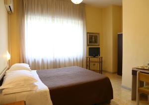 sypialnia z łóżkiem i dużym oknem w obiekcie Hotel Sole w mieście Nocera Inferiore