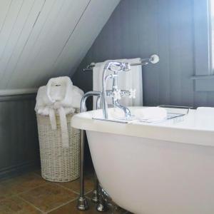 ein Badezimmer mit einem Waschbecken und einer Badewanne in der Unterkunft B&B Hillhouse in Lac-Brome