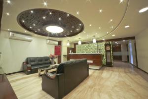 a lobby with a waiting room with a couch and a table at Hotel Grand Pragati in Surat