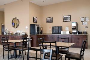 une salle d'attente avec des tables, des chaises et un comptoir dans l'établissement Cornerstone Inn & Suites Oelwein, à Oelwein