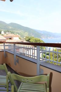 a green chair sitting on a balcony with a view at Seaview Apartment Monterosso, Cinque Terre in Monterosso al Mare