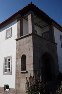 a white building with an archway on the side of it at 100Mordomias in Viana do Castelo