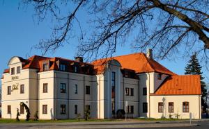 un gran edificio blanco con techo naranja en Hotel Skala, en Biała Podlaska
