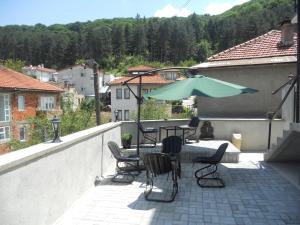a patio with a table and chairs and an umbrella at NULI apartments in Kruševo