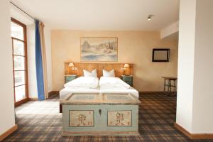 una camera da letto con un grande letto con cuscini bianchi di DIE POST Landgasthof Aufkirchen a Berg am Starnberger See