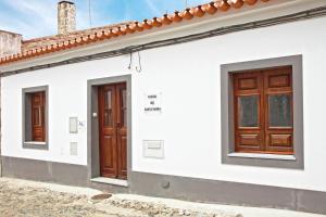 a white house with wooden doors on it at Pinheiro de Monsaraz- Casa De Santa Maria T3 com piscina in Reguengos de Monsaraz