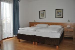 Schlafzimmer mit einem Bett mit weißer Bettwäsche in der Unterkunft Gästehaus Pension Edelweiss in Kolsass