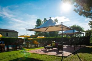 a large blue and white umbrella in a yard at Hotel Torricella in Magione