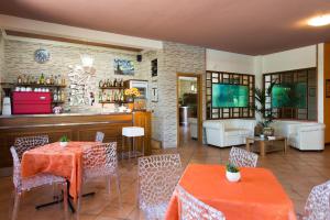 a restaurant with tables and chairs and a living room at Hotel Torricella in Magione