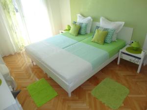 a large bed in a room with green pillows at Apartments Veronika in Makarska