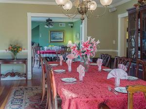 uma sala de jantar com uma mesa com uma toalha de mesa vermelha em George Brooks House B&B em Saint Michaels
