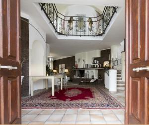a living room with a staircase and a red rug at Stella Moresca Luxury Villa in Calasetta