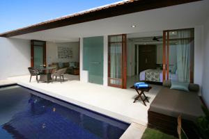 a villa with a swimming pool and a bedroom at Smart Comfort Apartments in Sanur