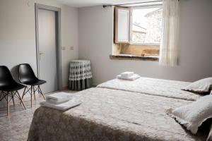 sypialnia z dwoma łóżkami i oknem w obiekcie Pension Casa Maruja w mieście Castromayor