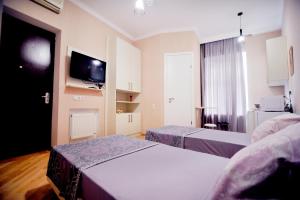 une chambre d'hôtel avec deux lits et une télévision dans l'établissement Old Arsena Apartments, à Tbilissi