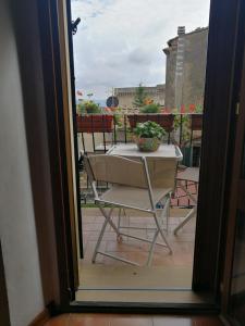 a table and chairs on a balcony with a window at Toscanamente in Volterra