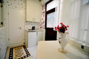 un vase avec des fleurs assis sur une table dans une cuisine dans l'établissement Old Arsena Apartments, à Tbilissi 16 autres photos