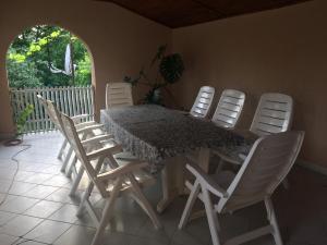 a table with four white chairs around it at Private House in Berehove +19 photos