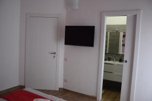a white room with a television on a wall at Beranu Rooms Villasimius in Villasimius