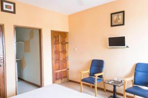 a room with two chairs and a tv on the wall at Cheers Guesthouse in Bortianor