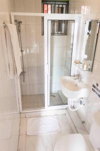 a white bathroom with a shower and a sink at Cheers Guesthouse in Botianaw +42 photos