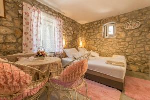 ein Schlafzimmer mit einem Bett, einem Tisch und Stühlen in der Unterkunft Holiday Home Godinj in Donje Rašćane