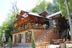 a wooden house with a balcony with people on it at Motel Lepo Mesto in Strmosten
