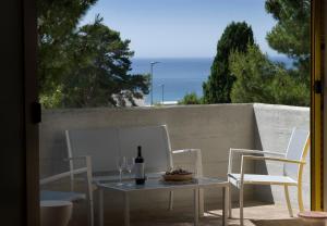 a table with two chairs and a bottle of wine at Casa la Mimosa in Leuca