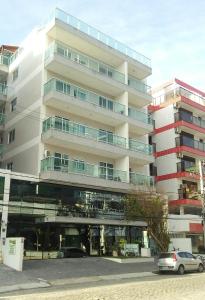 a large building with cars parked in front of it at Ótimo Apartamento 306, Arraial do Cabo, RJ, Brasil in Arraial do Cabo