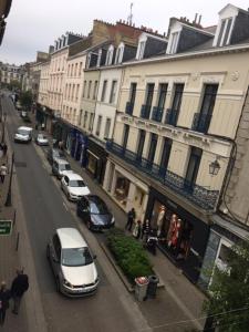 a group of cars parked on a street next to buildings at SAINT MALO Appartement in Saint Malo