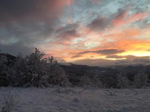 リオルナートにあるB&B Ca Dei Lenzottiの雪に覆われた丘の上の夕日