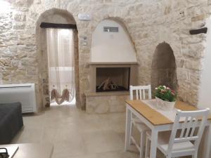 a living room with a table and a fireplace at Trulli Resort Grassi in Alberobello