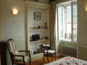 a room with a bed and a table and a window at Le Logis du Roc in Granville