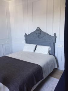 a bed with a blue headboard in a bedroom at SAINT MALO Appartement in Saint Malo