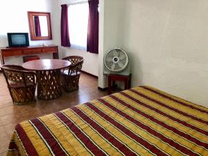 Schlafzimmer mit einem Bett, einem Tisch und einem Ventilator in der Unterkunft Hotel Roma in Oaxaca de Juárez