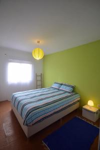 1 dormitorio con cama y pared verde en Happy Cat House - Holiday Rental, en São Martinho do Porto