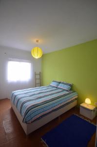 サン・マルティーニョ・ド・ポルトにあるHappy Cat House - Holiday Rentalの緑の壁、ベッド付きのベッドルーム1室