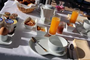 einen Tisch mit einem Frühstücksteller und Orangensaft in der Unterkunft Hôtel Restaurant La Montagne De Brancion in Martailly-lès-Brancion