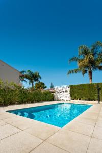 una piscina en un patio con palmeras en Hotel Villamor, en Denia