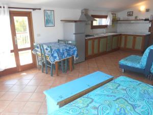 a living room with a table and a kitchen at Villatramontistella in Capoliveri