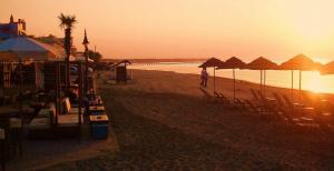 a person walking on the beach at sunset at Hotel Avra in Perea