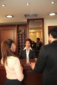 a woman is standing in front of a mirror at Hotel Avra in Perea